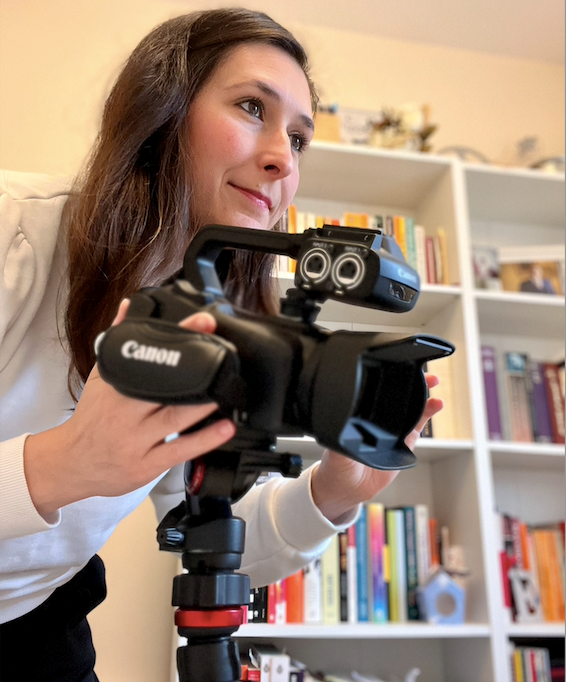 Someone is setting the frame of a camera. The background is shelves of books.