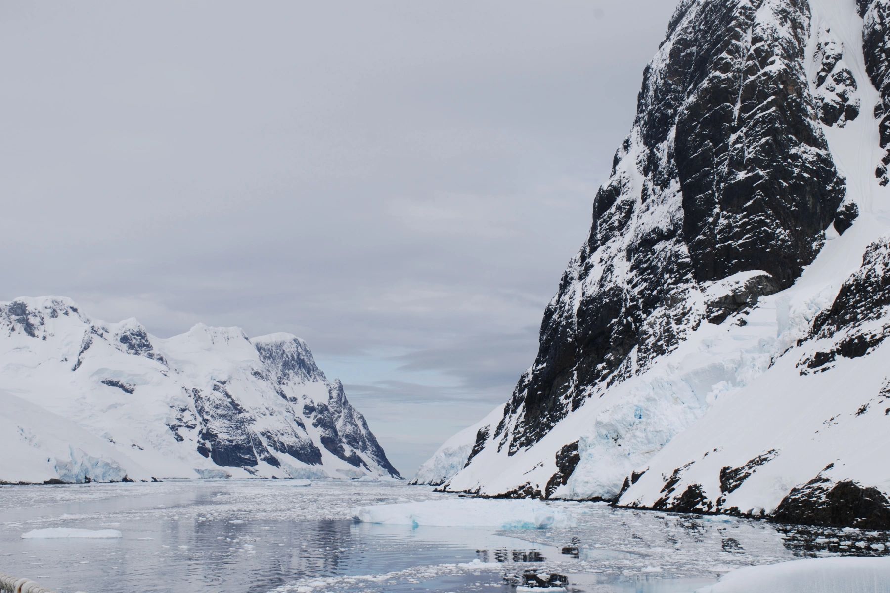 A frozen valley between two snow-covered mountains.