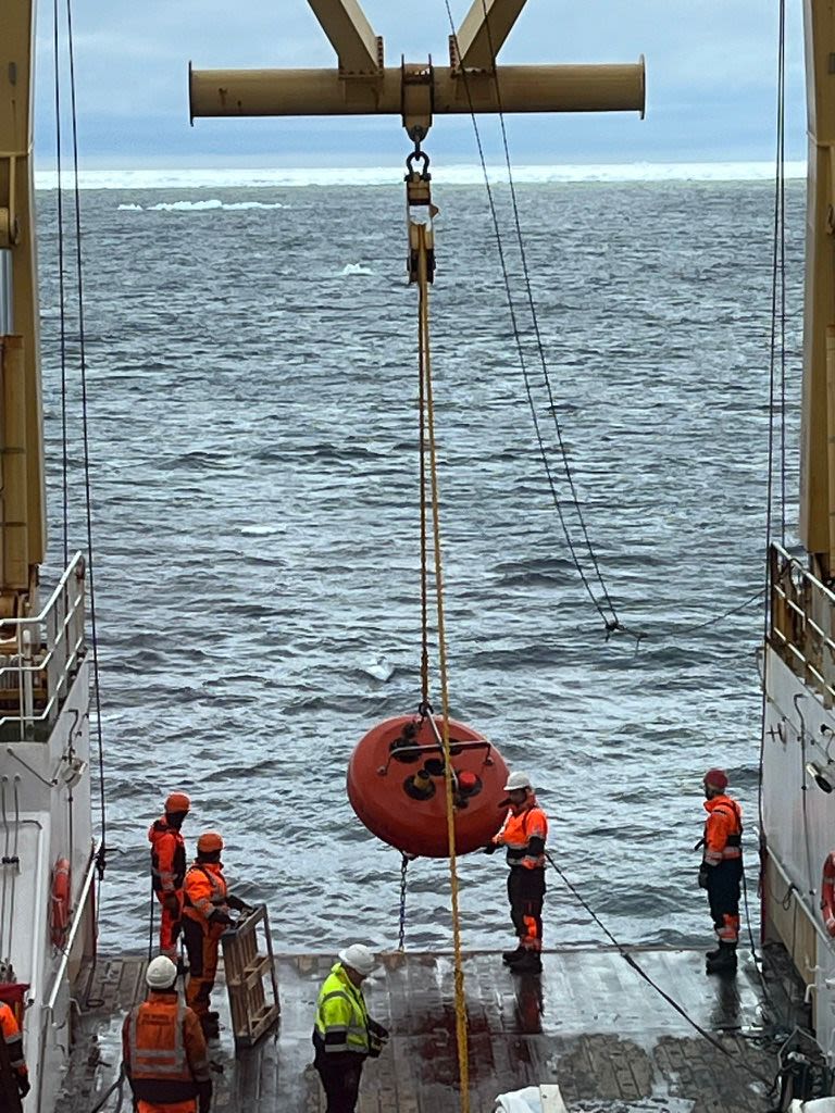 Taken from higher up, we see the mooring being raised.